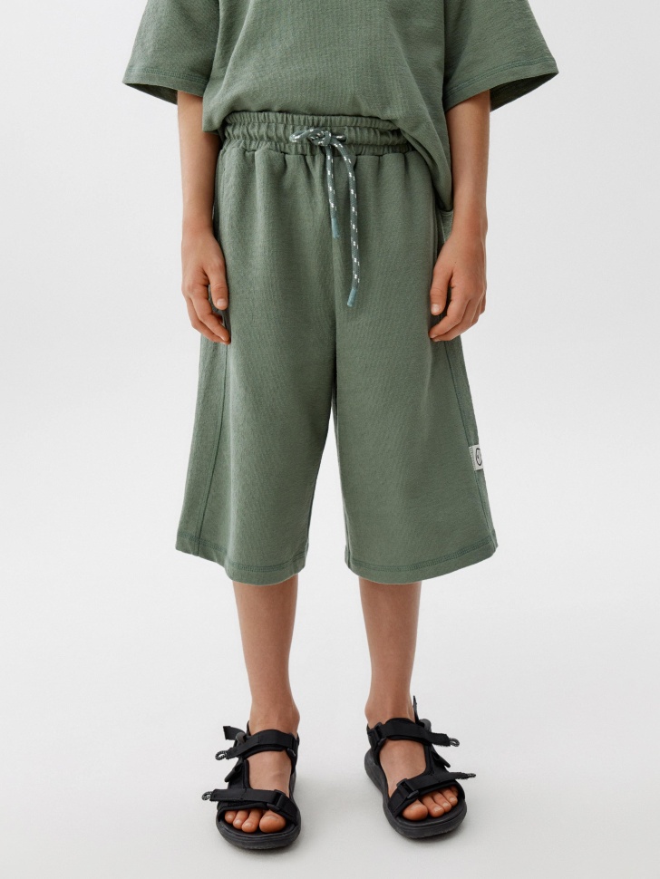 удлиненные трикотажные шорты для мальчиков от бренда sela вид слева