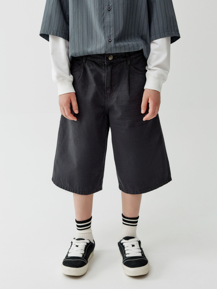 удлиненные шорты из фактурного хлопка для мальчиков от бренда sela вид слева