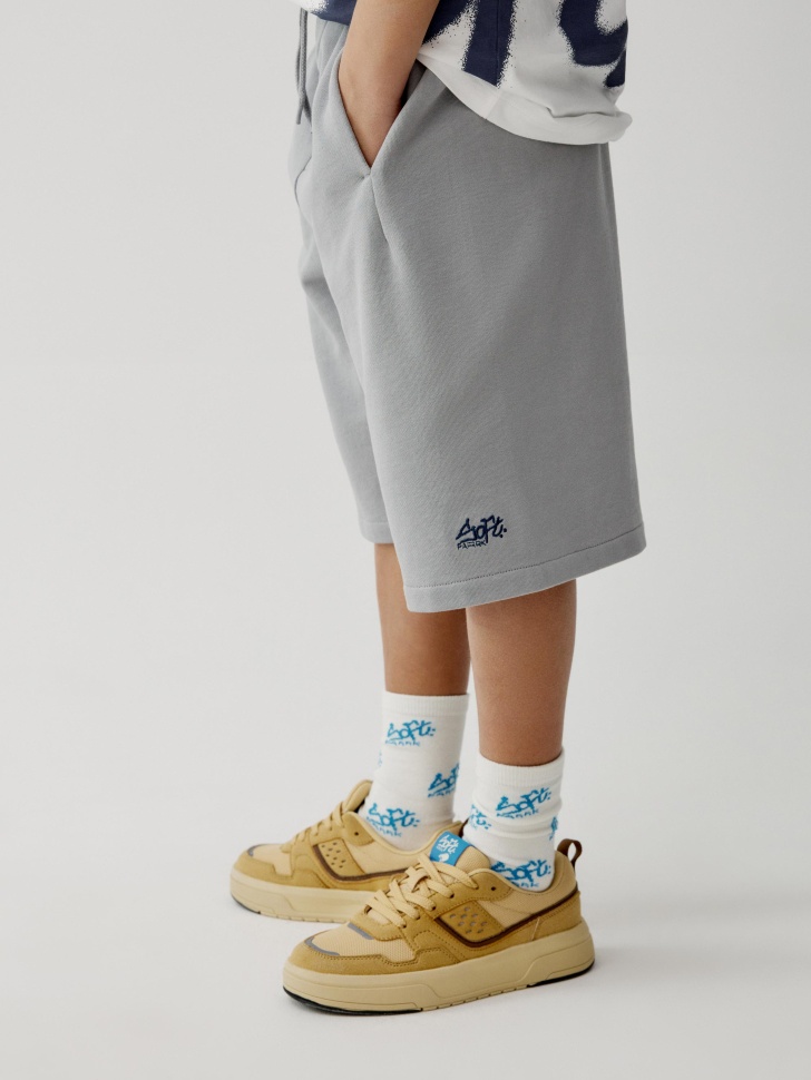 трикотажные удлиненные шорты для мальчиков от бренда sela вид слева